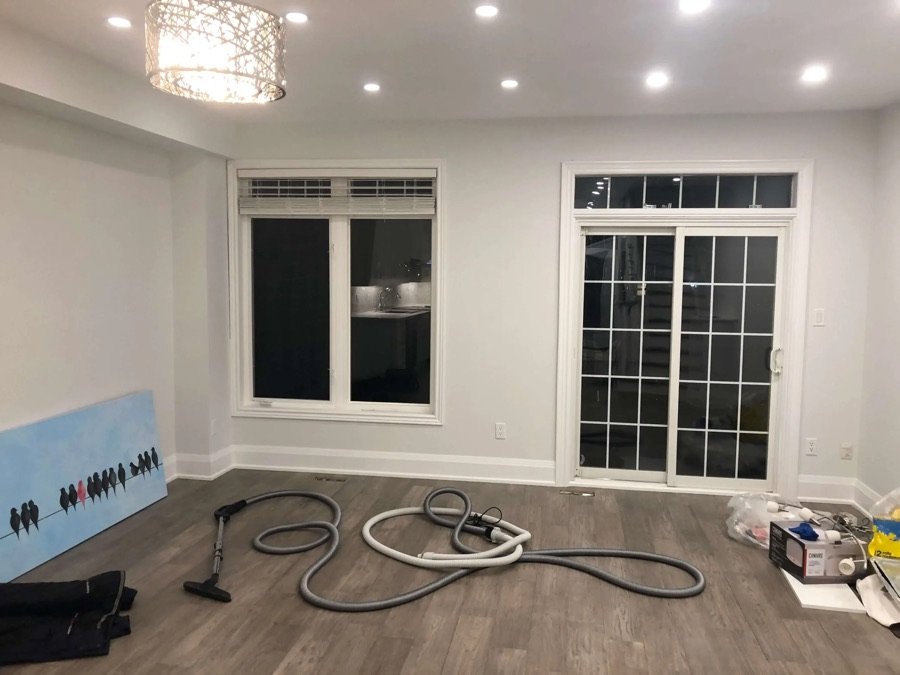 modern room with wood floor sliding glass door vacuum hose and overhead lighting