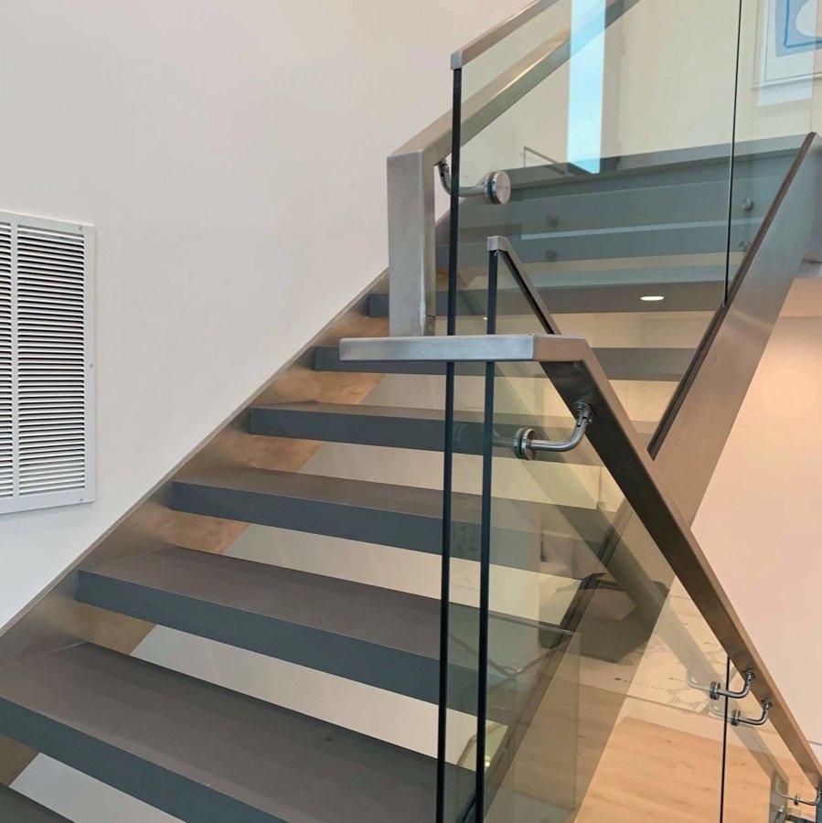 modern staircase with glass railing and metal handrail in contemporary home interior