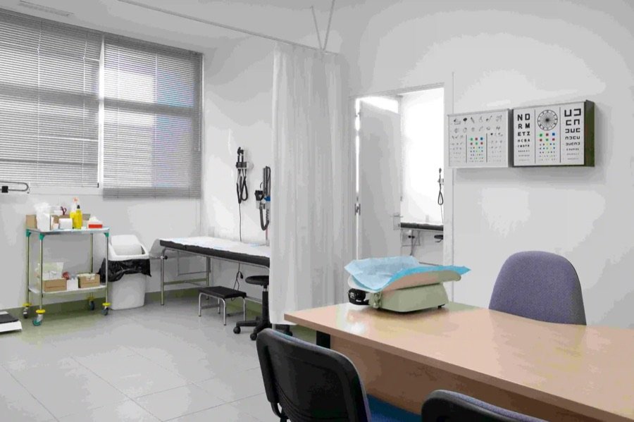 medical examination room renovation with clean layout exam tables equipment blinds tiled flooring and privacy curtain Ontario clinic renovation
