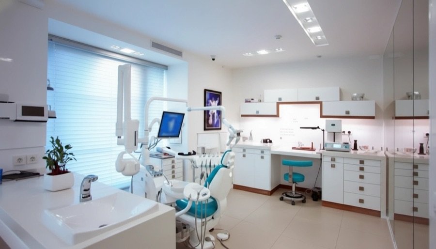 Newly renovated clinic reception area in Toronto featuring modern lighting, minimalist seating, wood accents, and a clean medical-grade design.
