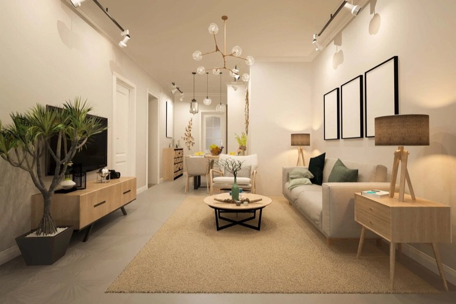 Narrow renovated living room with soft lighting, light-toned furniture, indoor plants, and a functional open-plan layout connecting to dining area