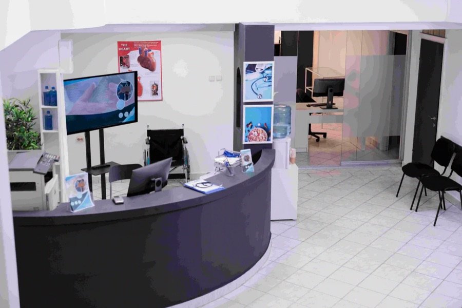 medical clinic reception renovation with modern front desk tiled flooring wheelchair access computer setup and healthcare posters in Ontario