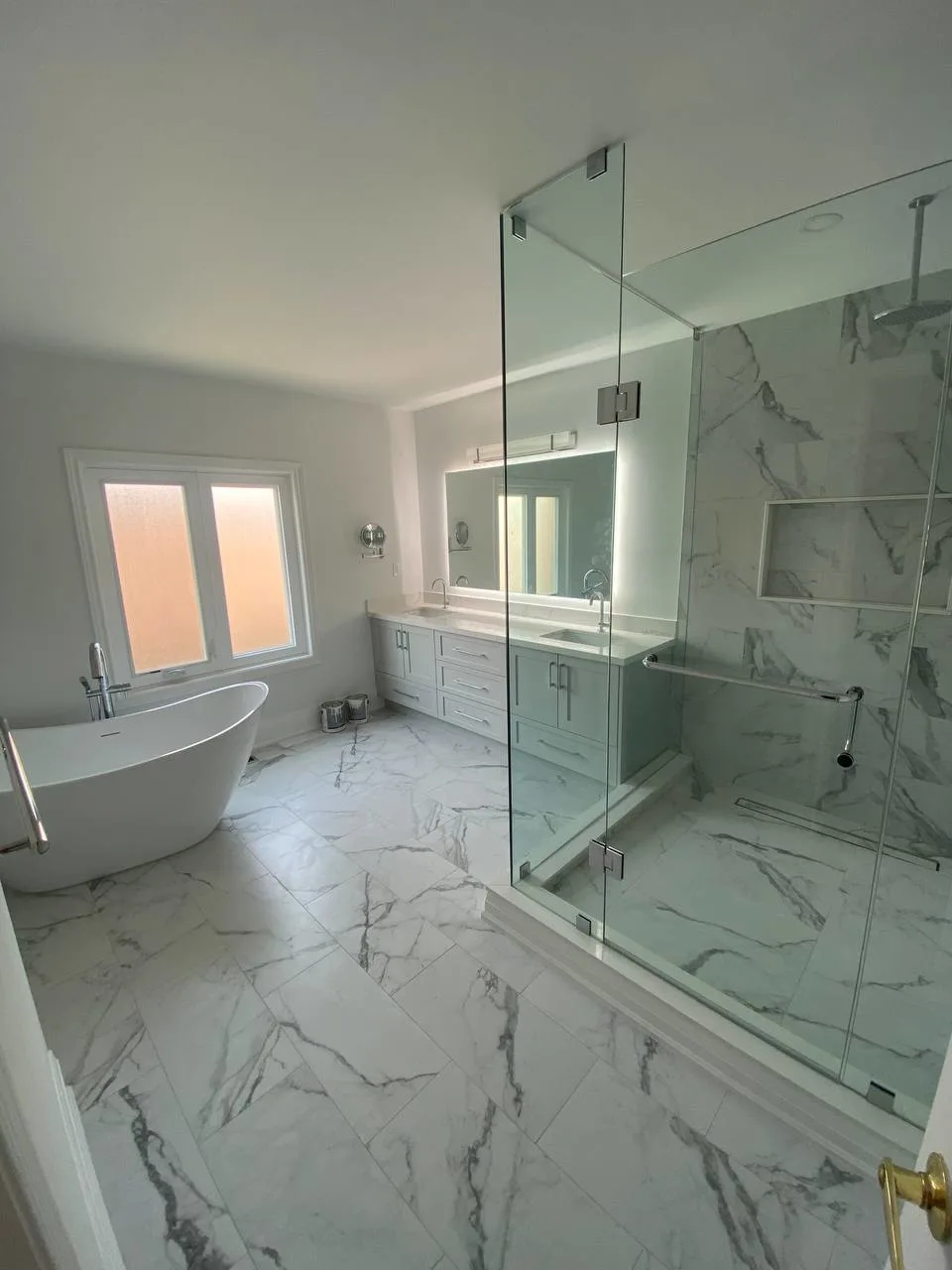 Bathroom with marble-look porcelain tiles and custom walk-in glass shower, completed by RM Renovation flooring and tiling team in Toronto